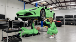 Green sports car being serviced indoors