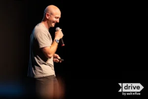 Man speaking on stage with microphone