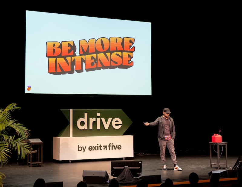 Louis Grenier on stage at Drive 2026 in front of a screen reading BE MORE INTENSE